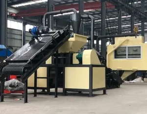 Industrial shredding system integrated with a conveyor belt for automatic material feeding.